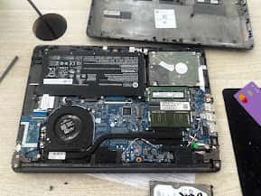 Interior de laptop mostrando motherboard, disco duro y RAM durante mantenimiento